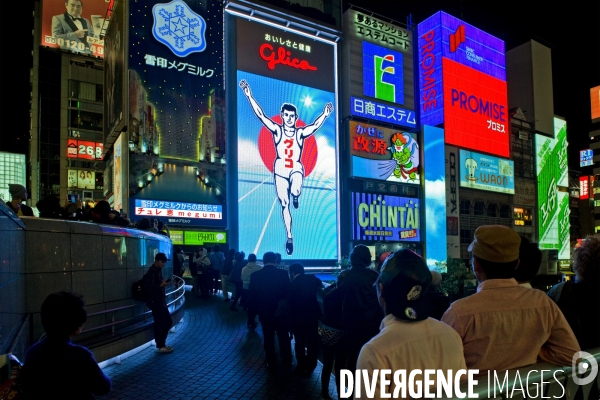 Osaka. Dans le quartier de Minami, l artere de Dotonbori concentre restaurants ,boutiques dans une debauche d enseignes lumineuses.Sur le canal, l animation, a heure fixe, du confiseur Glico