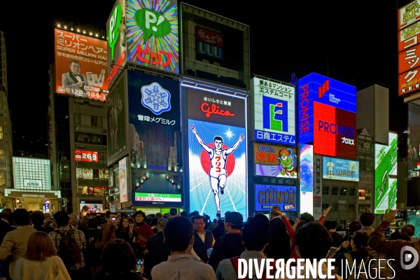 Osaka. Dans le quartier de Minami, l artere de Dotonbori concentre restaurants ,boutiques dans une debauche d enseignes lumineuses.Sur le canal, l animation, a heure fixe, du confiseur Glico