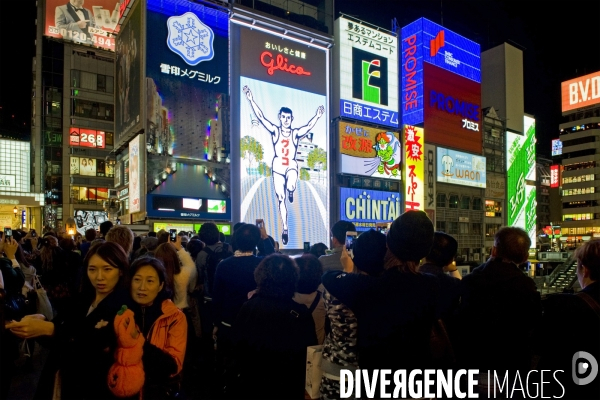 Osaka. Dans le quartier de Minami, l artere de Dotonbori concentre restaurants ,boutiques dans une debauche d enseignes lumineuses.Sur le canal, l animation, a heure fixe, du confiseur Glico