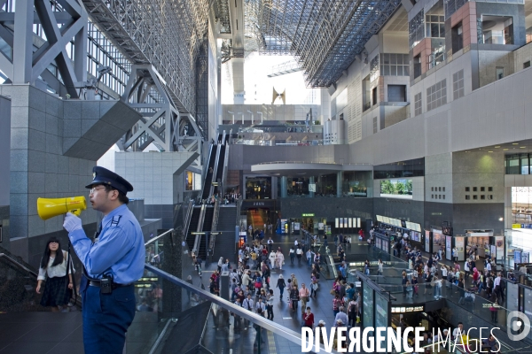 Kyoto.La gare centrale.Un agent  de securite avec son haut parleur assure la circulation des flux de