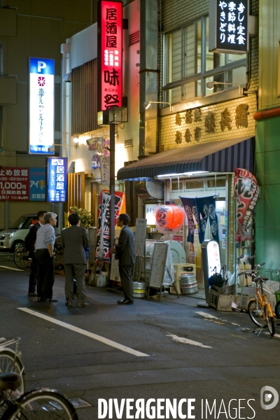 Japon. Tokushima.Des employes de bureau discutent le soir devant un restaurant