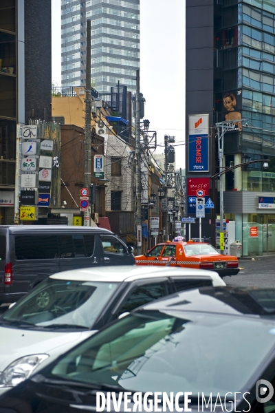 Tokyo.Au pied des tours dans le quartier de Midtown, une petite rue presque anachronique encombree de fils electriques