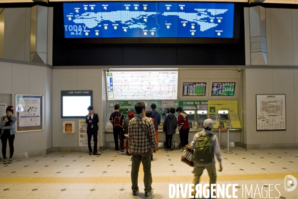 Tokyo.La gare centrale .Dans le hall, un tableau lumineux affiche les conditions meteo du jour.