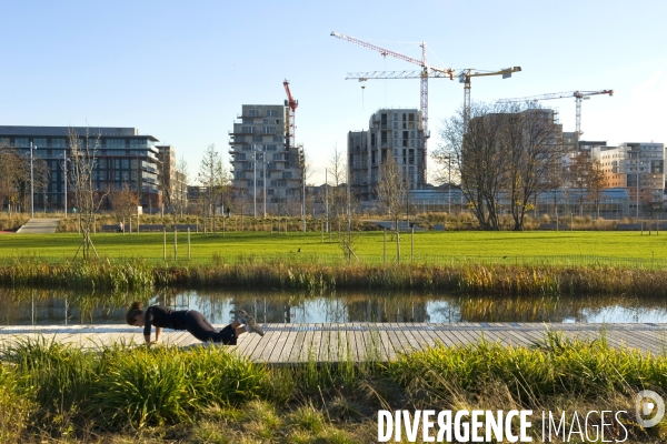 Illustration Décembre 2014.Le grand parc des Docks.Un joggeuse fait des exercises d assouplissement