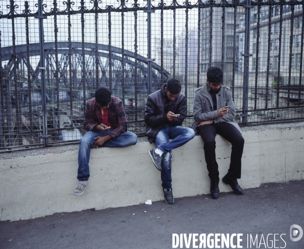 Paris Nord, jeunes immigrés jouant sur leur téléphone portable