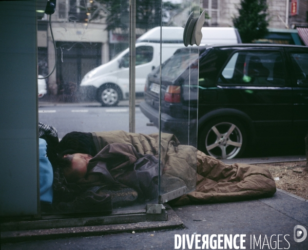 Paris en detail , Homme dormant dans une cabine téléphonique
