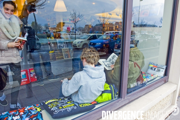 Illustration Avril 2015.Des enfants consultent des livres a la librairie la Galerne,
