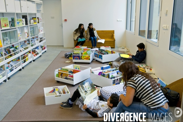 A la mediatheque Francoise Sagan a Paris, un enfant et sa mere lisent un livre
