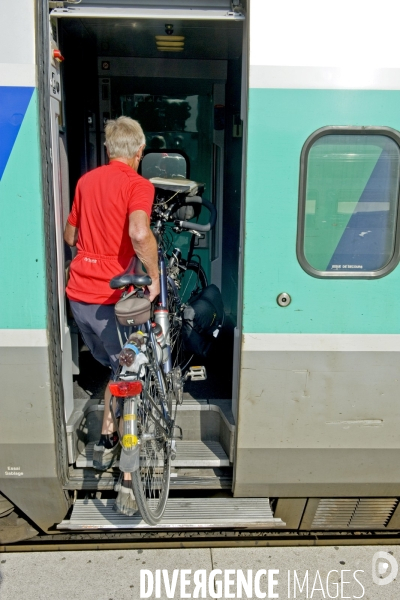 Illustration Juillet2015.Cyclotouriste embarquant un velo dans un tgv