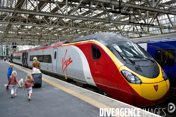 Glasgow.A la gare centrale, des enfants, un chien,et une femme, devant un train de la compagnie Virgin a destination de Paris.