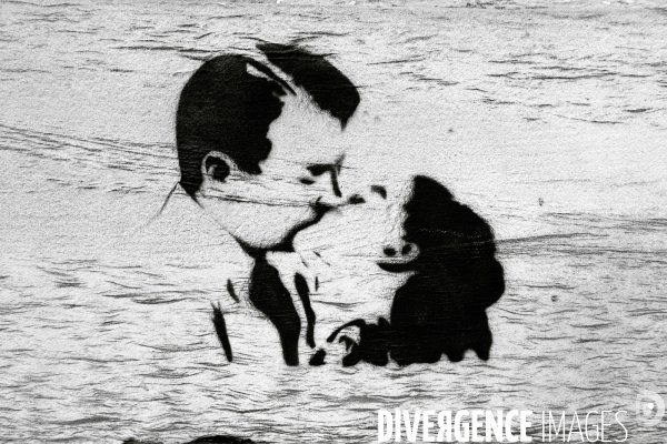 Glasgow.Love.Amour.Pochoir sur un mur.Le couple qui s embrasse semble etre au milieu des flots, illusion due aux asperites de la pierre.