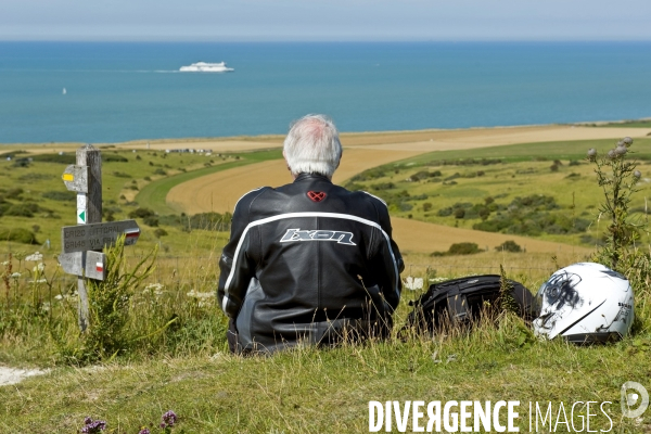 Illustration Aout 2015.Un motard assis dans l herbe du mont Saint Hubert, au cap Blanc Nez