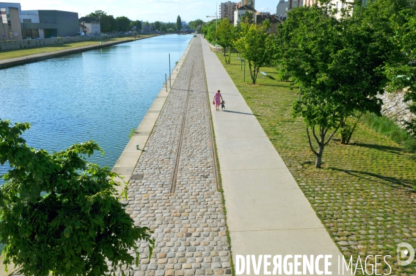 Des villes.Amenagement paysager sur la berge nord du canal Saint Denis.Une femme et un tres jeune enfant qui apprend a marcher