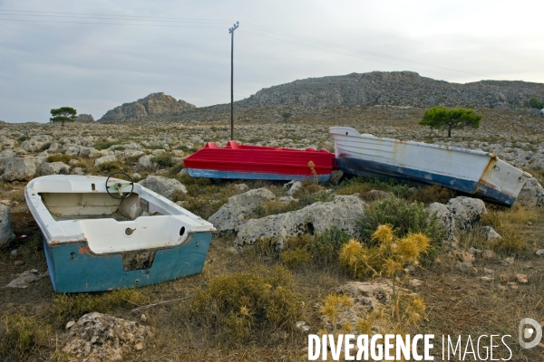 Fin de la saison touristique a Rhodes.Des barques abandonnees dans les rochers