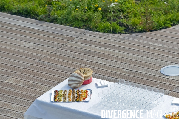 Illustration Octobre 2015.Petits fours, pain garni, verres vides, et serviettes en papier, la table est dressee pour une reception sur un toit terrasse
