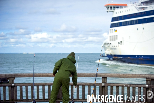 Illustration Octobre2015.Un pecheur au bout de la jetee,regarde un ferry P&O sortant du port de Calais