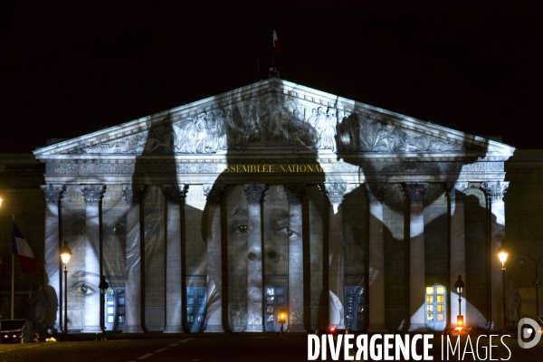 Projection video de The Standing March de l artiste JR et du realisateur Darren Aronofsky sur les colonnes de la facade de l assemblee nationale pendant la COP 21