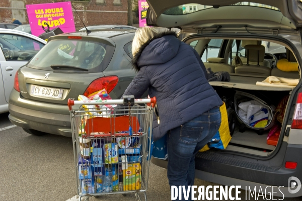 Illustration Fevrier2016.Une femme charge son coffre de voiture  avec ses courses au  supermarche  Match