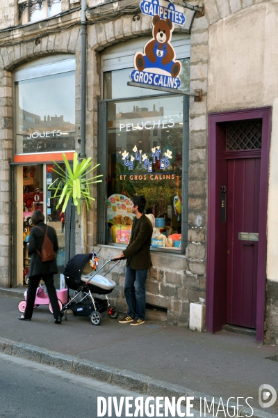 Lille.Dans le vieux lille, un jeune pere avec une poussette devant  une boutique de jouets