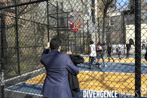 Retour a Manhattan # 01.Accroché a la grille d un terrain de basket, un homme en costume regarde le match