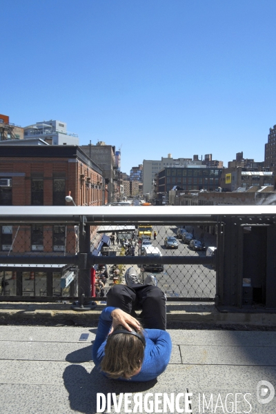 Retour a Manhattan # 01.Un homme au sol, fait des mouvements d assouplissement sur la High Line en ecoutant de la musique avec un casque.