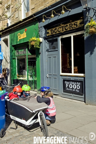 Edimbourg. Good boys ! Dans une remorque a velo, deux enfants casques attentifs a ce que leur raconte leur maman.